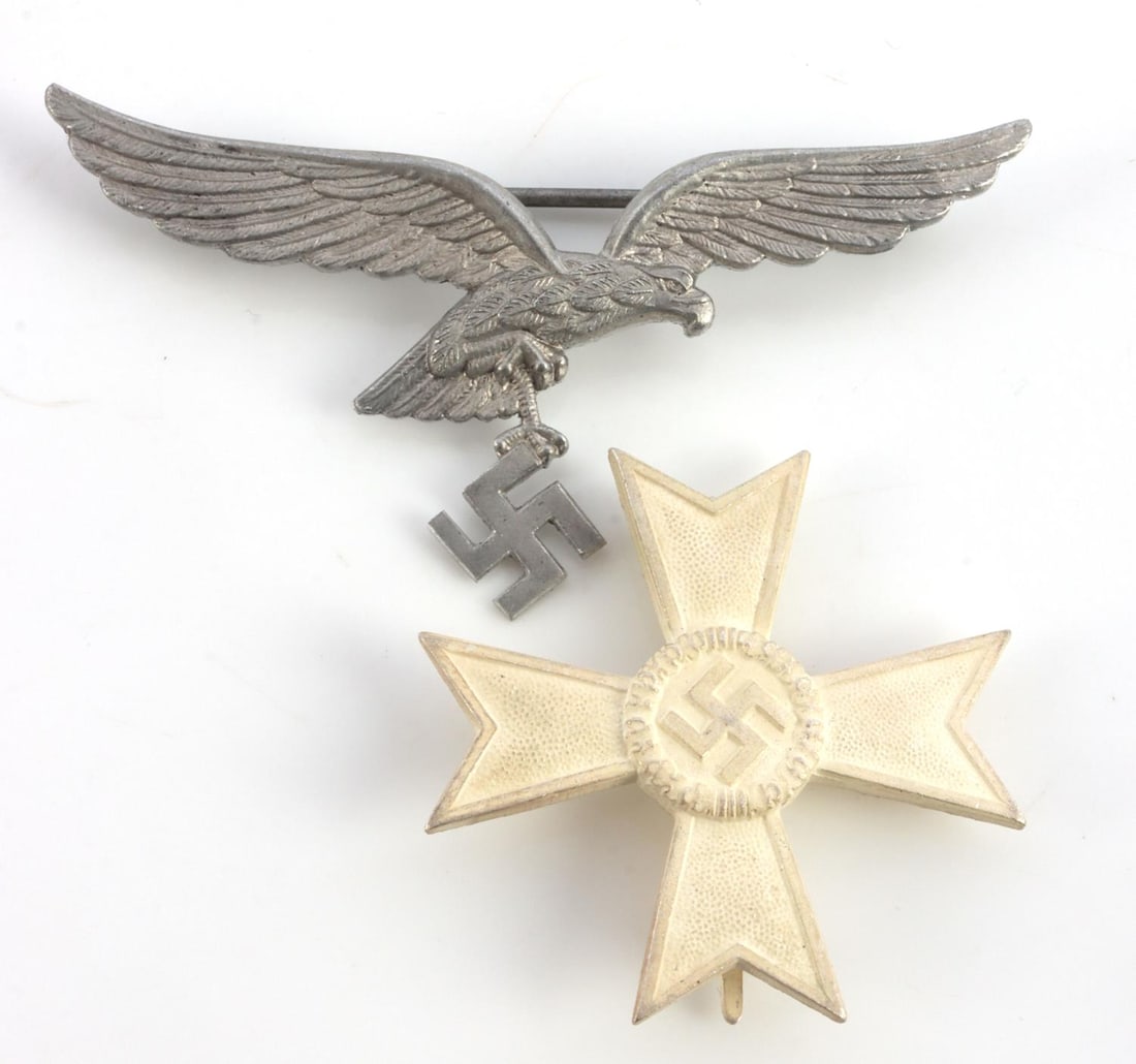 WWII GERMAN WAR MERIT CROSS & LUFTWAFFE PIN: Unissued War Merit cross and an aluminum Luftwaffe summer tunic Reichsadler pin. Cross is fully frosted and measures 1 7/8 inches with no maker's marks. Luftwaffe pin measures 3 1/4 inches and marked 