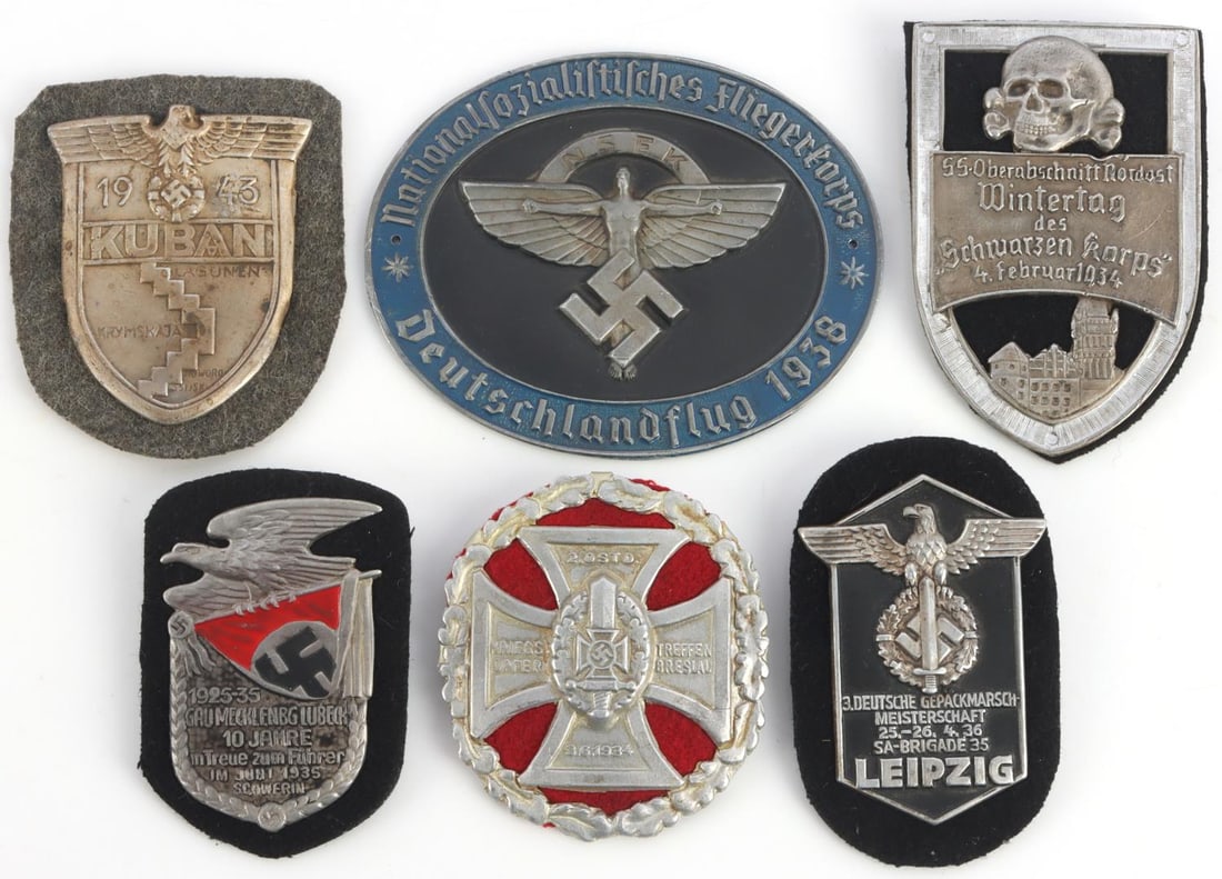 6 WWII GERMAN REICH KUBAN & SA SHIELD BADGES LOT: Lot of six (6) various WWII German Reich shield badges including a Kuban shield, a 1934 SS Wintertag "Schwarzen Korps" badge, a 1934 SA 35th Brigade March to Leipzig badge, 1938 NSFK Pilot's Champions