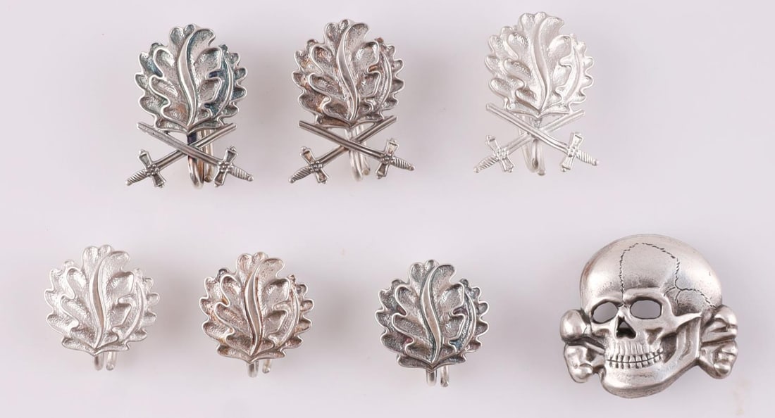 7 GERMAN REICH TOTENKOPF SKULL & KNIGHT'S LEAVES: Lot of seven (7) WWII German Reich badges including six Knight's Cross silver leaves and swords.(three marked 800, three marked 900). Lastly a Totenkopf skull cap badge, marked M1/52. Badge sizes rang