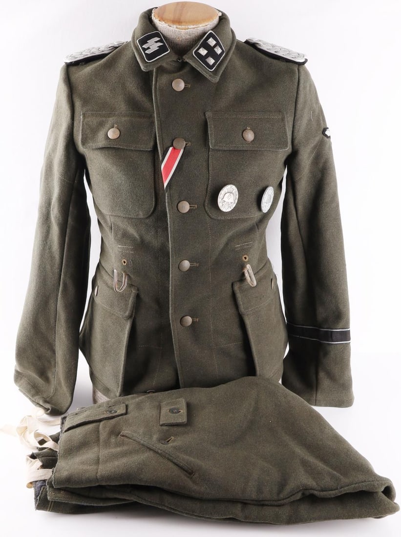 MUSEUM EXAMPLE WWII GERMAN STURMBANNFUHRER TUNIC: Tunic features SS collar tabs, eagle patch on left shoulder, Das Reich cuff title, pebbled buttons, and a wound badge marked 30. Non-fluorescing. Named to H. Dorn on interior left pocket. Size medium.