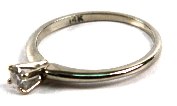 LADIES 14K WHITE GOLD & DIAMOND SOLITAIRE RING: Ladies 14K white gold and diamond solitaire ring. Features around cut diamond set in a four prong setting totaling approx. 0.15 cts. Size: 7 Weight: 1.8 g Condition: Diamond appears to have some fract