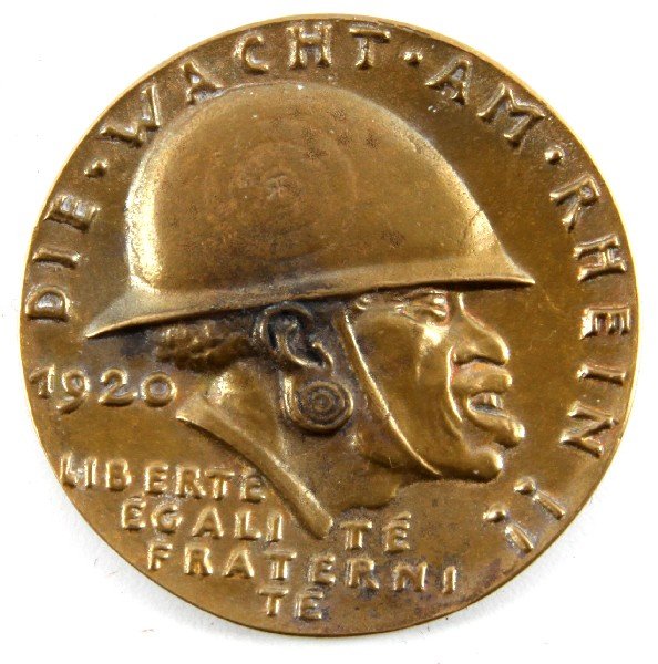 WWII GERMAN BRONZE GOETZ SCHWARZE SCHANDE MEDAL: Silver 1921 Anti-French propaganda table medal. Obverse bears an uncomplimentary profile of a helmeted French colonial soldier, with the slogan "DIE WACHT AM RHEIN" [The Watch/Guard on the Rhine]. Rev