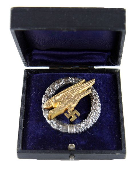 THIRD REICH NAMED LUFTWAFFE PARATROOPER BADGE: Luftwaffe Paratrooper Badge in original case stamped "G.E. JUNKER BERLIN SW" measures 3 by 1.5 inches and weighs 40.3 grams. Reverse of the eagle is inscribed "Sommerhage gespr. a. 8.10./16.10.40 vert