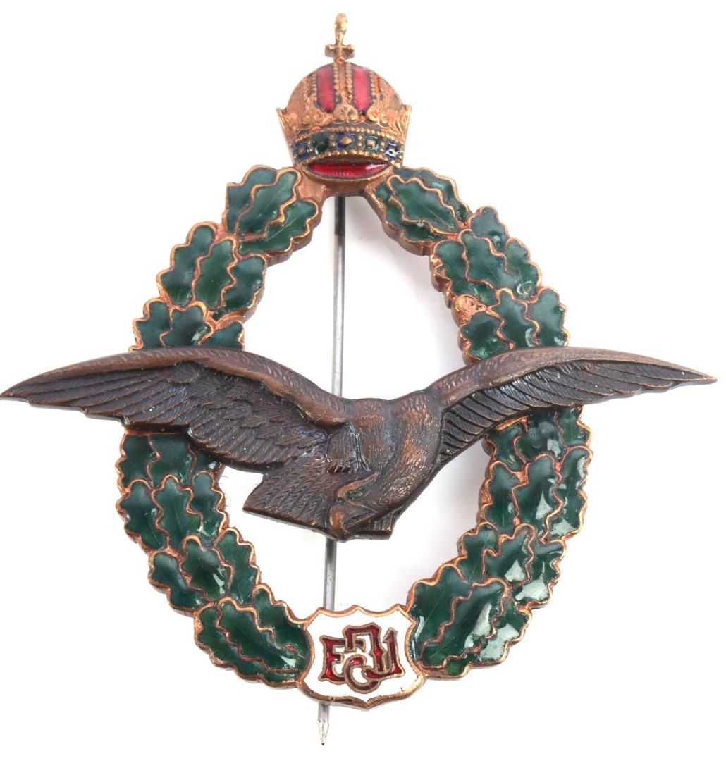 WWI AUSTRIAN BRONZE ENAMEL PILOTS BADGE J ZIMBLER: Bronze construction with enamel, crown at top, eagle at center, and FJ1 (Franz Joseph) in shield below, thin vertical pin back with C-hook closure, and J. Zimbler Wien. VII. to reverse. Very good cond