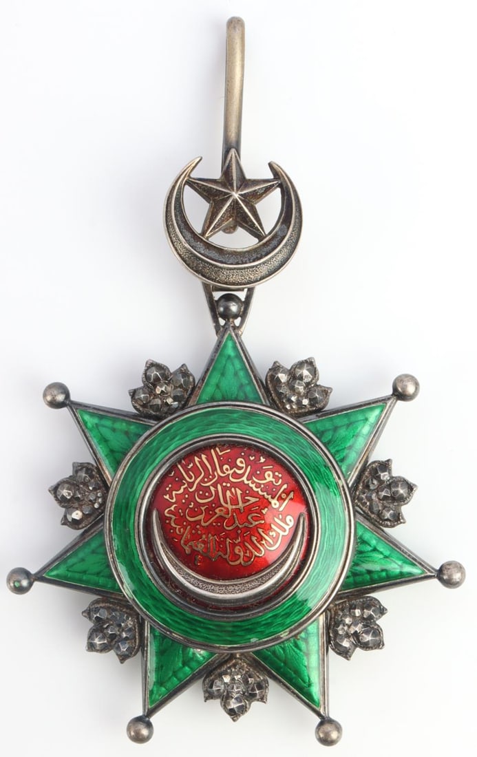 WWI TURKISH OTTOMAN EMPIRE ORDER OF OSMANIA MEDAL: One WWI Ottoman Empire Order of Osmania 3rd Class Commander's neck medal. Gilt silver with green enameled 7-pointed star. Green enameled circle to the center with a red interior with golden Arabic. Ar