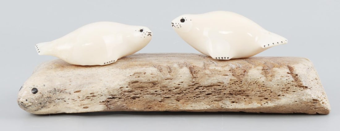 CHARLIE OLANNA ALASKA INUIT WALRUS TUSK SCULPTURE: Signed verso Charlie Olanna, fossil whalebone 2 seals carved with two Walrus tusk figures, beautiful work, measures 6 X 2 1/2 inches. This lot has a reserve.