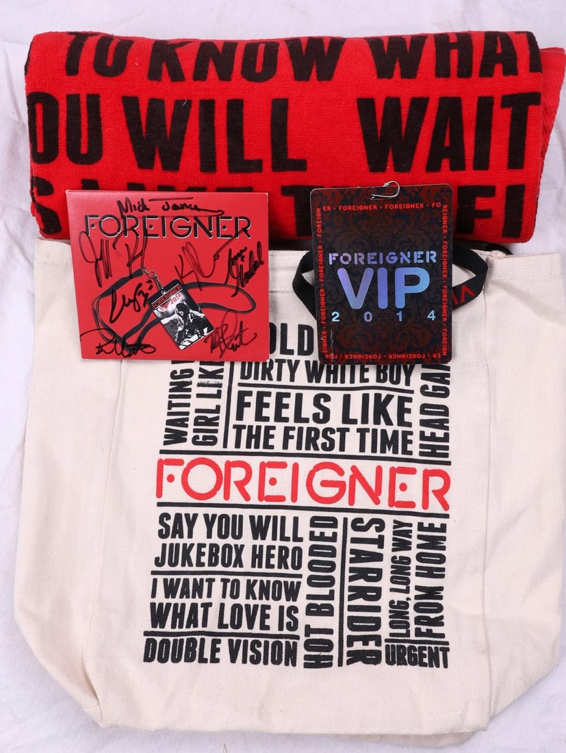 LIMITED EDITION 2014 FOREIGNER VIP SIGNED GIFT BAG: A Limited Edition 2014 Foreigner VIP gift bag which includes a VIP lanyard with Access Pass, a Foreigner beach towel, a CD cover signed by Mick Jones, Kelly Hansen, Chris Frazier, Deen Castronovo, Jef