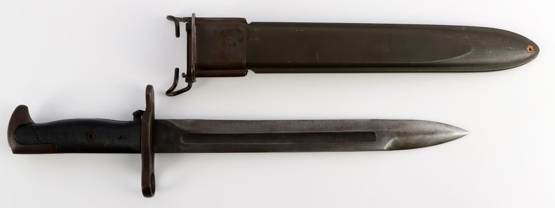 WWII US MILITARY M1 GARAND BAYONET & SCABBARD: US WWII M1 Garand bayonet. Ricasso is marked, "PAL" U.S 1943, with a flaming bomb(ordnance mark) between U and S. Darkened blued pommel and crossguard/muzzle ring. Ribbed black plastic grips. Scabbard