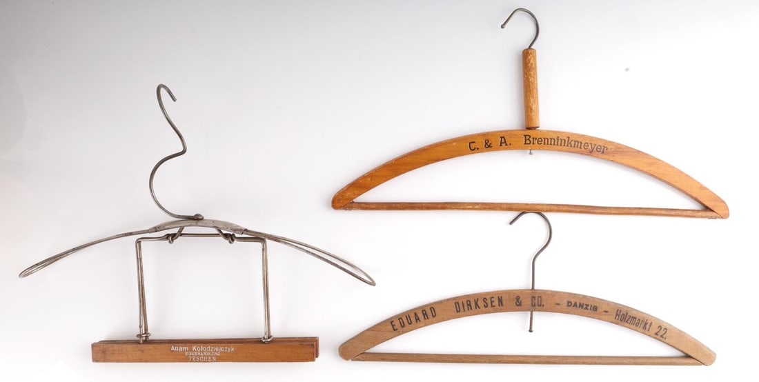 WWII GERMAN THIRD REICH CLOTHING HANGERS LOT OF 3: Lot of 3 clothing hangers. 1 C. & A. Brenninkmeyer hanger. 1 Adam Kolodziejczyk Eisenhandlung Teschen hanger. 1 Eduard Dirksen & Comapny Danzie Holzmarkt 22 hanger. All are in very good condition. Dim