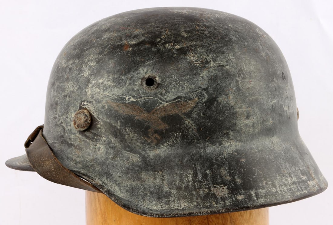 WWII GERMAN LUFTWAFFE M38 HELMET: Snow camo, colors decal removed leaving shadow, chin strap, 8 finger liner no tie, stamped 9225 reverse, Q62 left ear, very good original condition. Unauthenticated, sold as is.