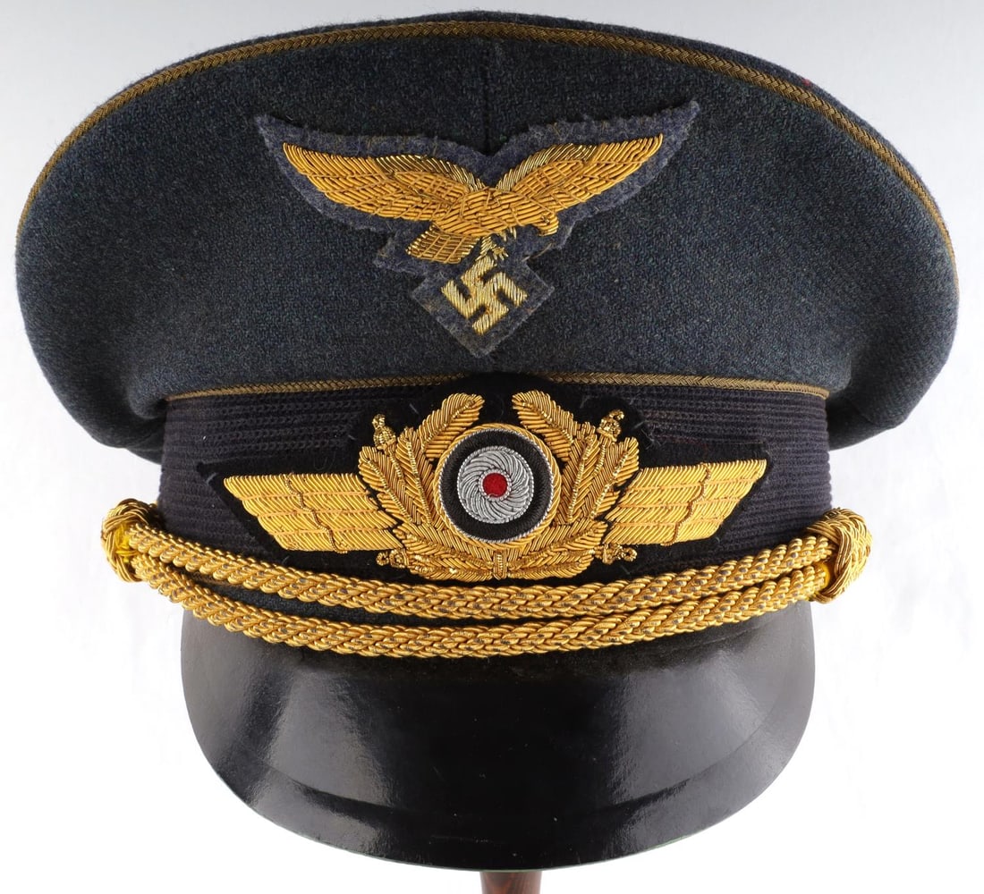 WWII GERMAN LUFTWAFFE PAUL CONRATH VISOR: Blue visor with gold piping, cockade, and chin cord. Luftwaffe patch is also gold bullion. Size 58. Non-fluorescing. Very good condition.