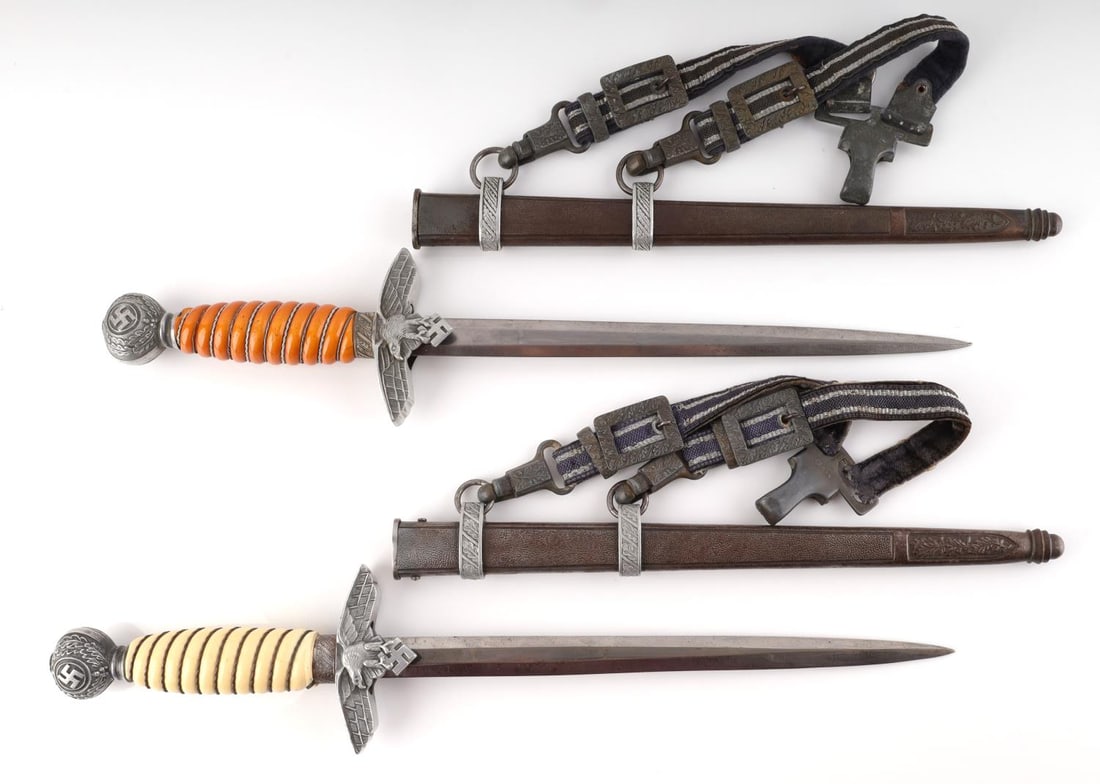 LOT OF 2 WWII GERMAN LUFTWAFFE MODEL 2 DAGGERS: Steel blades, Bakelite grips, aluminum crossguard and pommel. Both come with blue dagger hangers that are marked DRGM U. E. 10 RZM. Very good condition overall. They measure 16 5/8 inches. Small chip