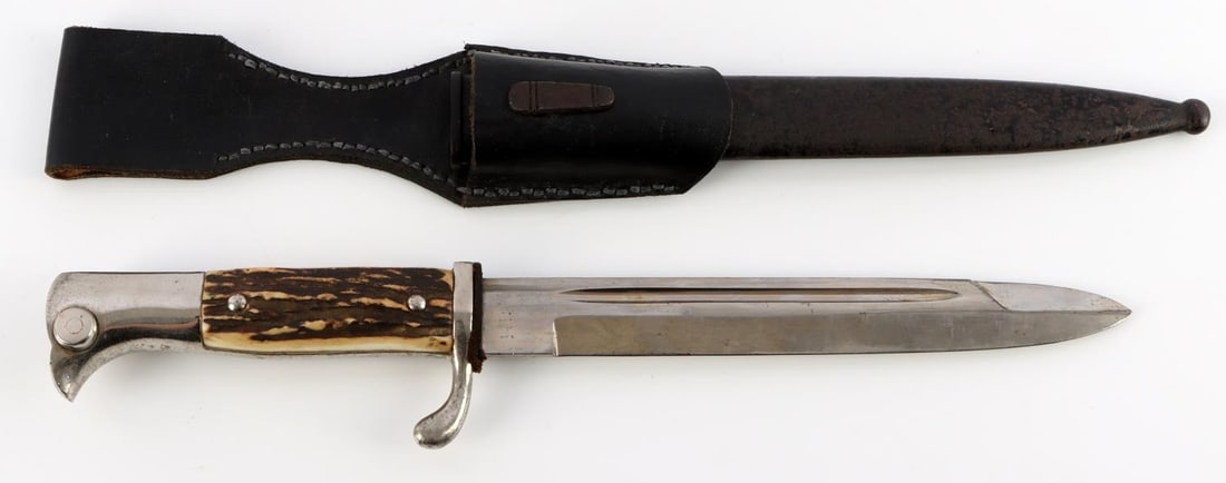 WWII GERMAN THIRD REICH EICKHORN DRESS BAYONET: One measuring 13 3/4 inches in total length when inserted into the scabbard. It features a 7 1/2 inch long, nickel-plated, magnetic steel blade with a sharpened tip and lower edge. A fuller runs the m