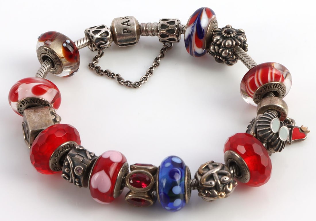 PANDORA STERLING SILVER CHARM BRACELET: 8 inch sterling silver Pandora designer bracelet with 15 charms.