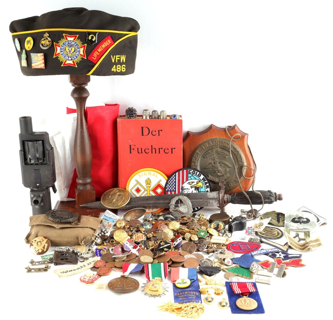 LOT OF ASSORTED MILITARY BADGES MEDALS BOOK HAT: An assorted lot of military gear, medals, buttons, jet engine starter, current Japanese flag, belt buckles, coins. Sold as is.