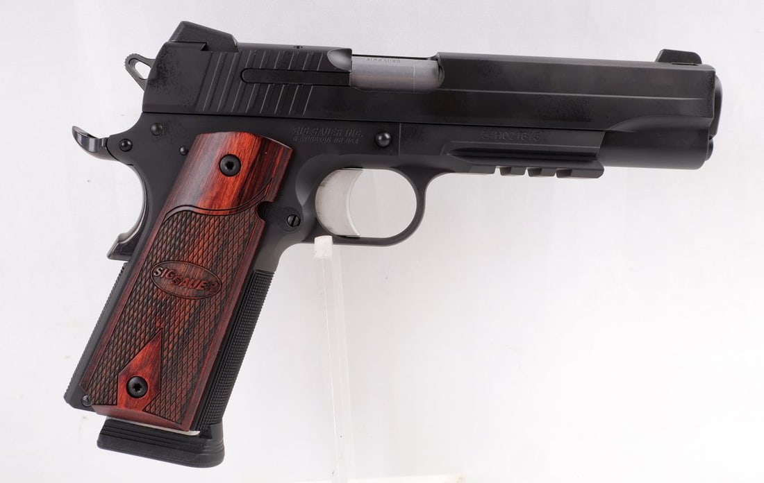 SIG SAUER 1911 .45 SEMI AUTO PISTOL NIB: Brand new in box. Two magazines included. Rosewood grip , Picatinny rail, 5" carbon steel barrel. FFL required for transfer. No international shipping. Know your state's firearm laws prior to bidding.
