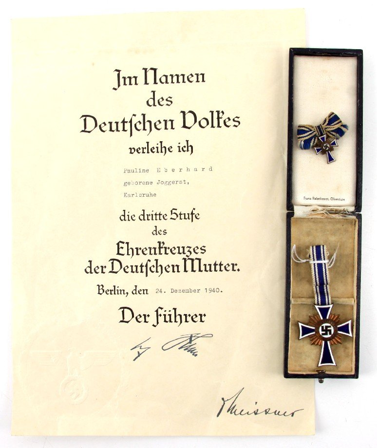 NAZI MUTTEREHRENKREUZ MEDAL IN BOX WITH DOCUMENT: Ehrenkreuz der Deutschen Mutter (Cross of Honor of the German Mother) named document awarding the Mother's Cross, First Class (for eight or more children). Original presentation box is marked "Franz R