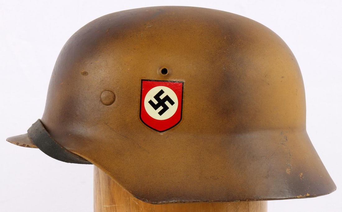 WWII M40 GERMAN SS DAK CAMO HELMET: Original helmet, 1939 dated chinstrap, rear stamped EK106 over 6517 over 64, original suspension, when camo and decals come in, are indeterminate, even if restored a very fine example.