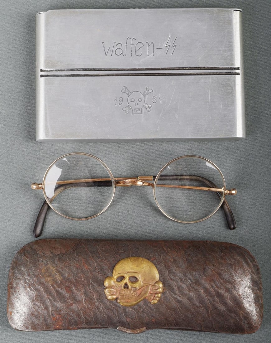 WWII GERMAN EYE GLASS & CASE & CIGAR HOLDER LOT: Lot includes 1 WWII German Third Reich Waffen SS officials eyeglasses. Round shape, small chip on the left lens, gilt metal frame. The glasses come in a metal case and a gilt overlay Totenkopf skull i