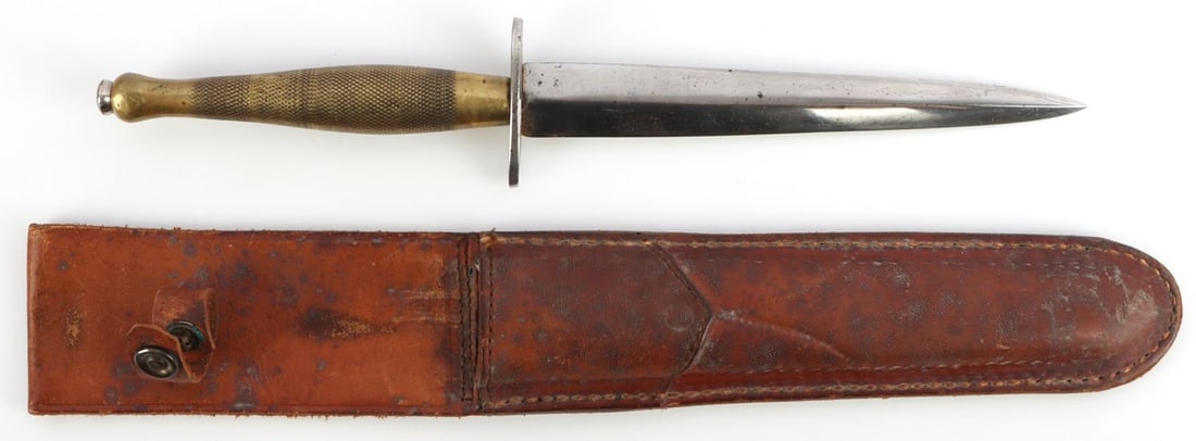 WWII BRITISH FAIRBAIRN SYKES D-012 COMMANDO KNIFE: D-012 British WWII Fairbairn Sykes commando knife with leather sheath. 2nd pattern style with a brass grip and a 6 5/8" thick blade that has been sharpened. Crossguard's underside is stamped, "ENGLAND