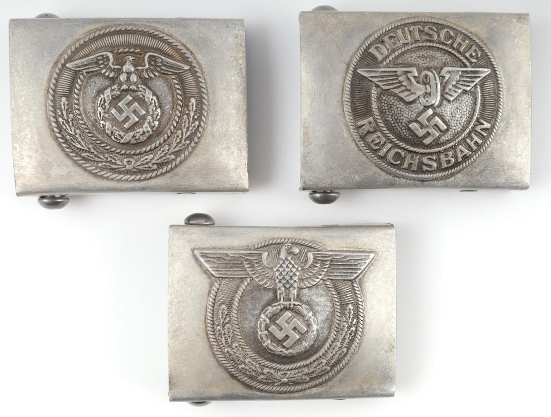 GERMAN WWII LOT OF 3 BELT BUCKLE SA REICHSBAHN: Lot of 3 German WWII belt buckles. Identified as SA, Reichsbahn, and Police. All are marked RZM on back and measure 2.5 inches in width and 2 inches in height. Metal is tarnished. Unauthorized and sol