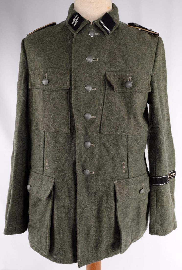 WWII GERMAN THIRD REICH SS M44 FIELD TUNIC SIZE L: Field tunic with collar tabs, shoulder boards, Parteiadler patch, and a cuff title. Collar tabs do not fluoresce, but shoulder boards do. Interior thread does not fluoresce. Large size tunic. Very goo