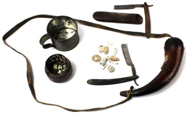 CIVIL WAR POWDER HORN RAZOR CUP HOTCHKISS SHELL: Variety lot of Civil War gear includes exploded Hotchkiss shell dated 1855, Sutter straight razor, wood handled razor with nail repair, powder horn marked Welloville Block House, tin cup, and a bag of