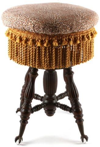 ADJUSTABLE OAK PIANO STOOL WITH BALL AND CLAW FEET: Four legged piano stool in oak with padded upholstered seat and fringe. 16 inch diameter seat. Metal claw feet with glass balls are all intact. Swivel-screw height adjuster. Very good condition.