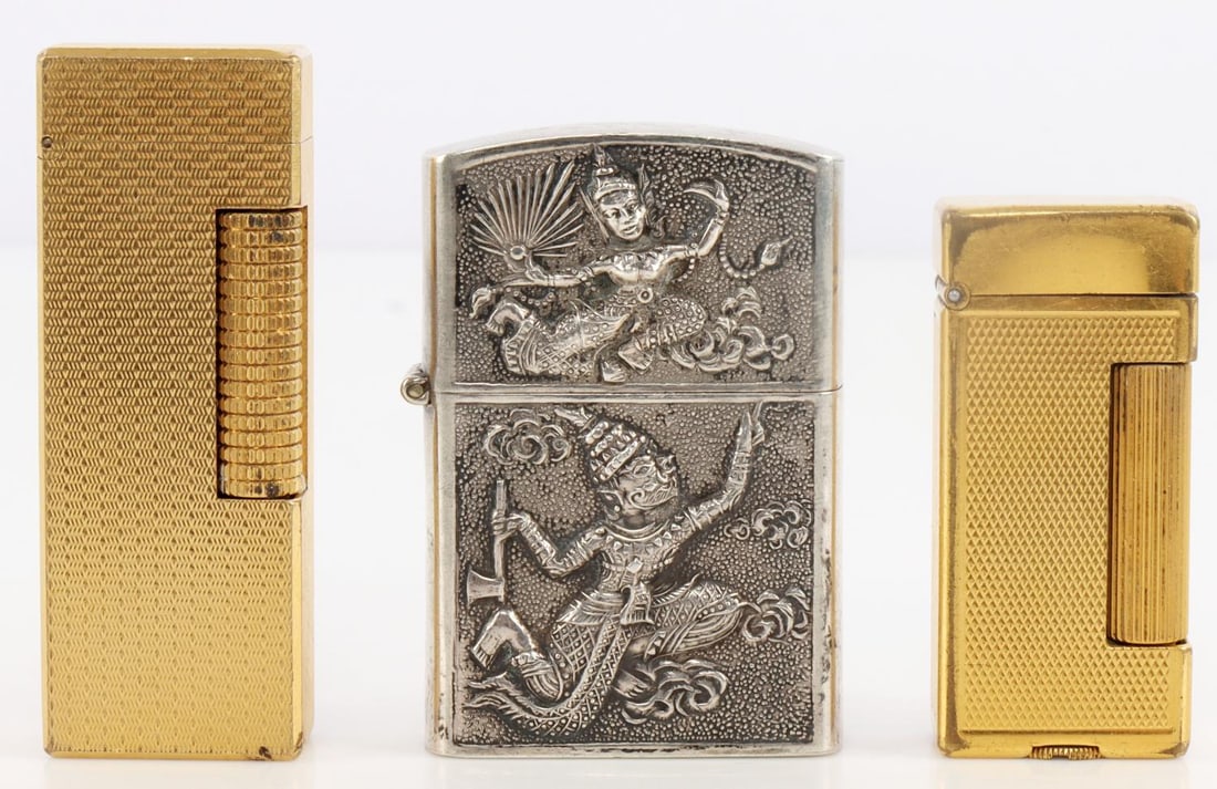 LOT 3 DUNHILL MID CENTURY & SIAM SILVER LIGHTERS: Lot of 3. Includes gold-plated lighter stamped "Dunhill, made in Switzerland," 2.5X1 inches, gold-plated Dunhill lighter stamped "Dunhill London, made in Switzerland," 2X1 inches, and silver lighter w