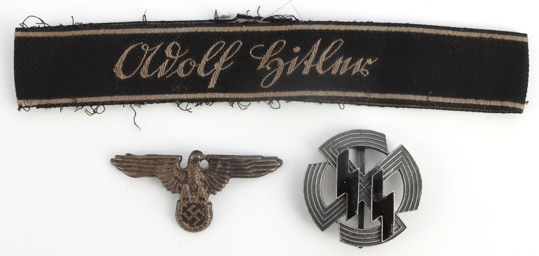 LOT OF 3 WWII GERMAN ADOLF HITLER CUFF & MORE: Lot features a non-fluorescing Adolf Hitler cuff title, SS Parteiadler visor pin, and SS sports badge . Measurements range 1.75 - 7.5 inches. Unauthenticated, sold as is. 0