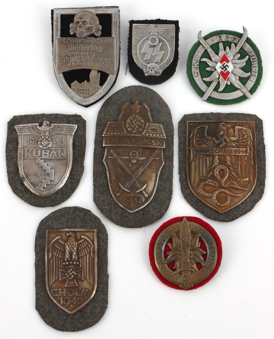 LOT 8 WWII GERMAN THIRD REICH SHIELD AWARD BADGES: Lot of 8 WWII German Third Reich sleeve shields. 1942 Cholm (2.5X1.5 inches), 1943 Kuban (2.25X1.75 inches), 1944 Warsaw (2.75X2.25 inches), 1942 Demjansk (3.5X2 inches), Hitler Jugend Ski Fuhrer (2 i
