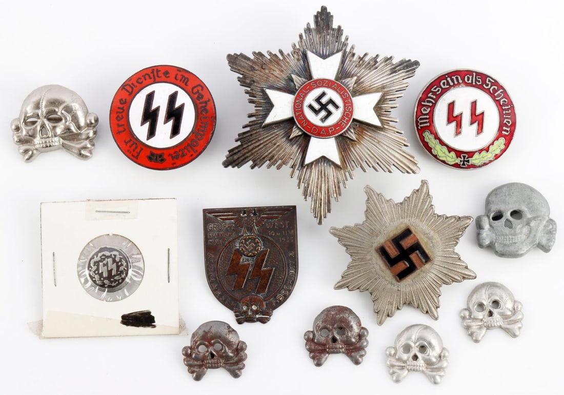 WWII GERMAN THIRD REICH MEDAL LOT OF 12: 1 German SS Wolfschanze pin, für treue dienste im geheimpolizei" written around it. 1 SS Silver button. 6 WW2 German Totenkopy pins 2 are steel. Enamled center of a SS Breast Star Mehrsein Als Schein