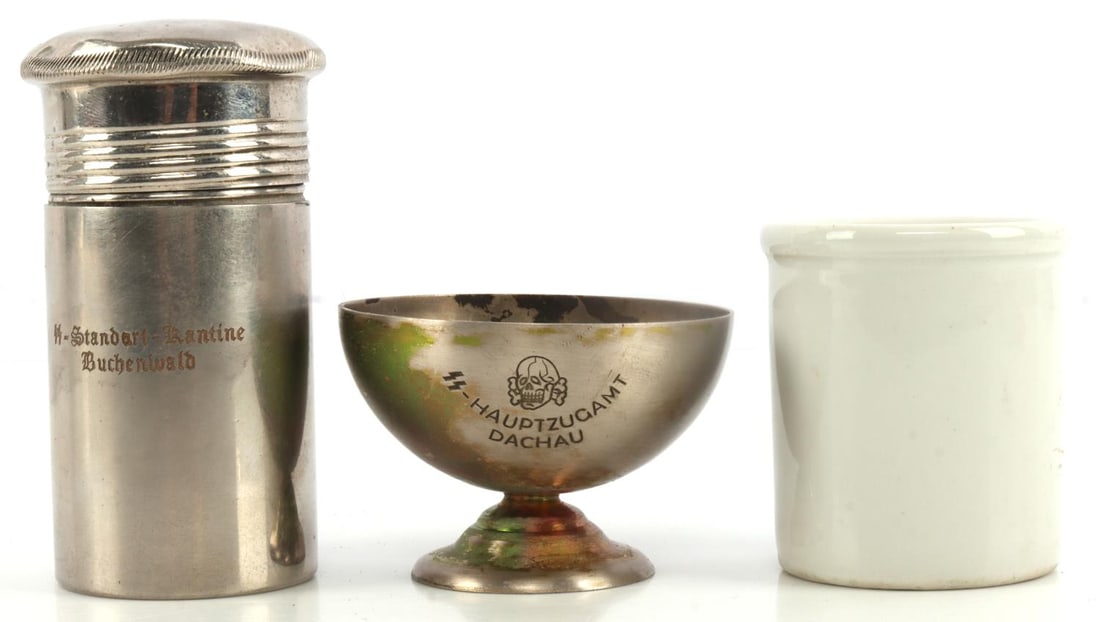 WWII GERMAN SS MRDICAL CUP PEPER SHAKER CUP LOT: WWII white ceramic medical cup from the concentration camp Dachau SS Lazarett. Stamped "SS Lazarett Munchen Dachau". Measures 2.5 inches tall. Unauthenticated, sold as is. WWII German SS metal cup. En