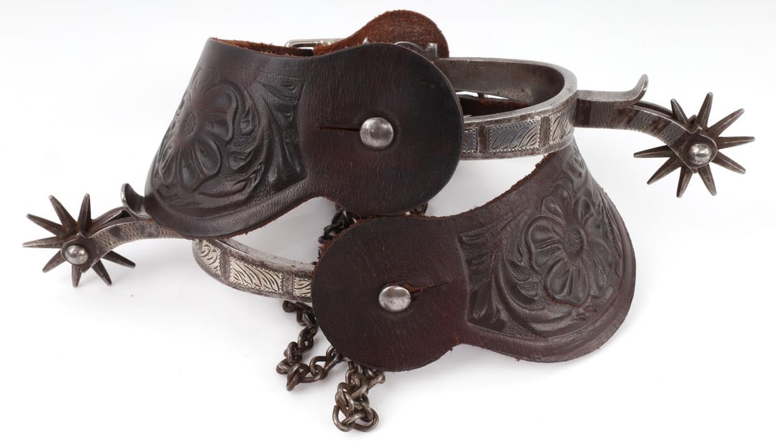 VINTAGE AUGUST BUERMANN O.K. STYLE SILVER SPURS: Pair of Vintage Oklahoma Style Spurs hand forged by August Buermann. Spurs feature a leather strap, spur heel chains, two buttons, two-piece steel construction of heel band and shank, single mounted s