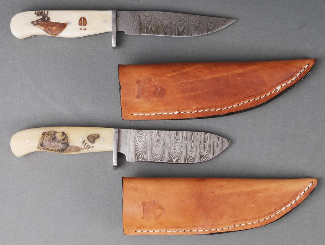 LOT OF 2 LONE WOLF DAMASCUS STEEL KNIVES W SHEATH: Lot of two (2) Lone Wolf Damascus Steel blade knives with leather sheaths. First knife features a spear-point blade, single etched hilt, a bone grip handle with six rivets and a full steel tang. This 