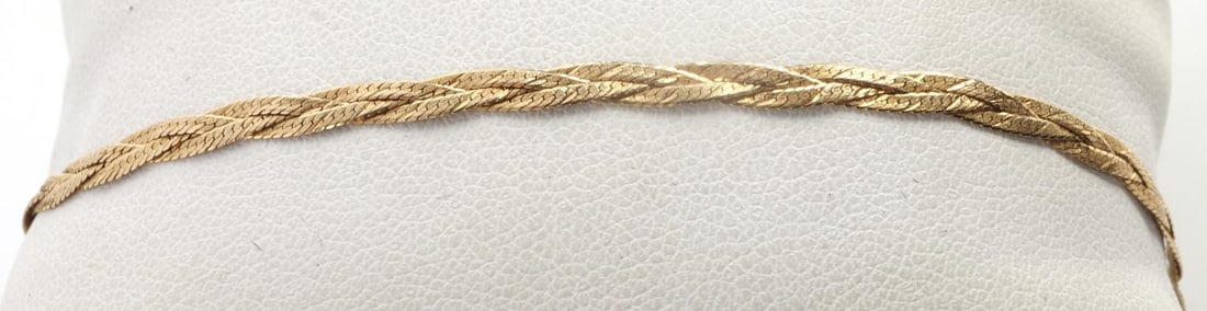 14K YELLOW GOLD BRAIDED HERRING BONE BRACELET: Stamped "14KT" and measures 6.25 inches. Total weight 1.5 grams. This lot has a reserve.
