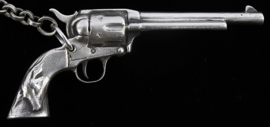 STERLING SILVER REVOLVER PISTOL WATCH FOB: Measures 10 inches for chain and revolver measures 3.5 inches. Revolver is decorative and does not fire bullets. Total weight 58.4 grams. Stamped sterling on butt of revolver. This lot has a reserve.