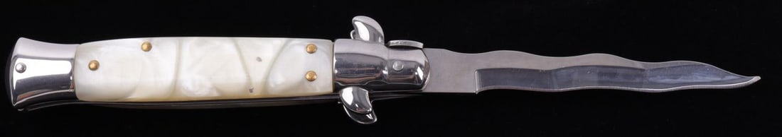 AKC ITALY SWITCHBLADE LEVERLETTO WAVY BLADE KNIFE: Steel blade with white composite grip. It measures 8 7/9 inches.