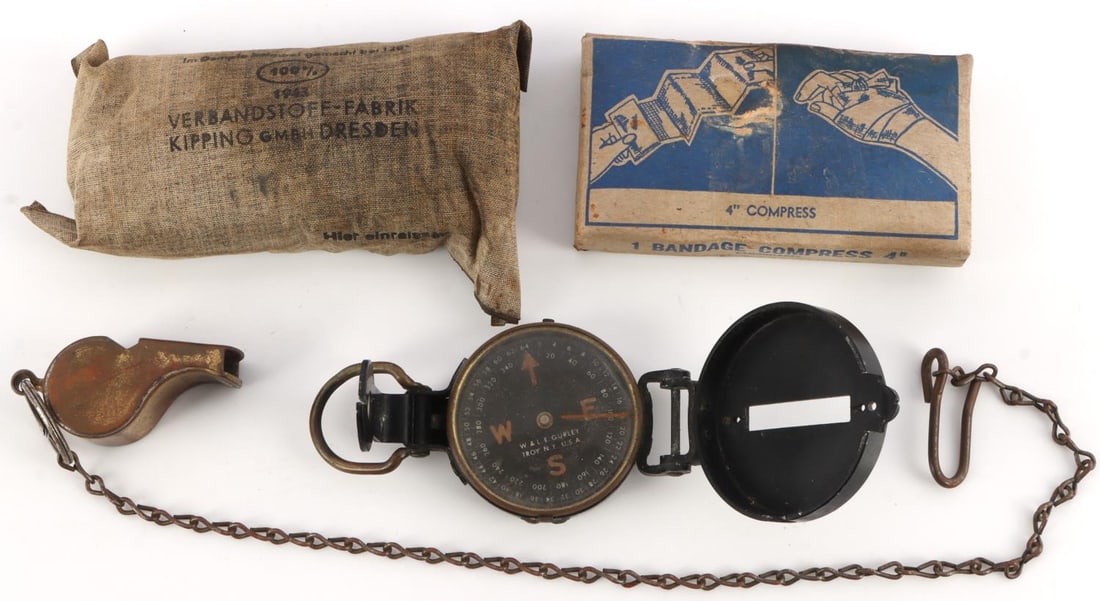 WWII GERMAN & AMERICAN BANDAGE KITS AND GEAR LOT 4: Lot of 4 WWII artifacts. American brass military whistle with clip and chain. W.& L.E. Gurley brand directional compass. Camouflaged military bandage compress made by AE Halperin. German cotton bandag
