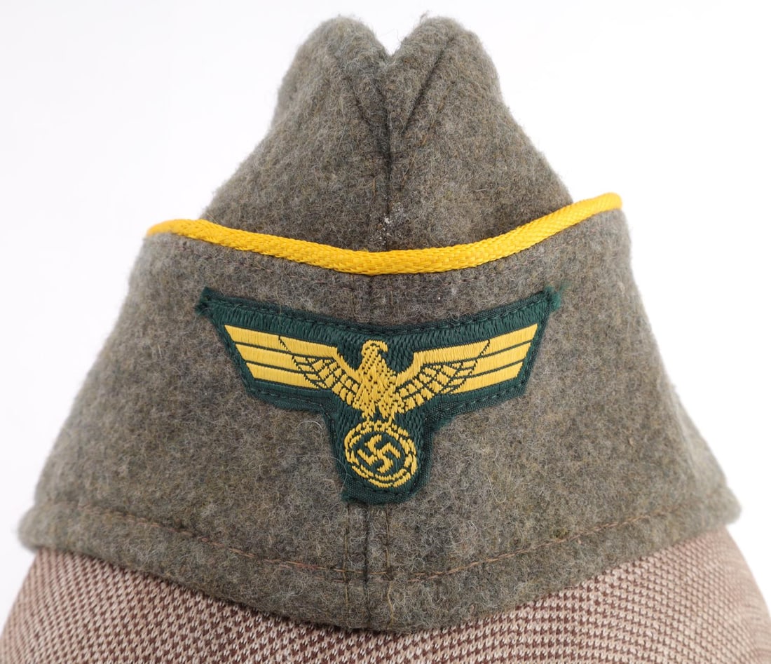 WWII KRIEGSMARINE COASTAL ARTILLERY OVERSEAS CAP: WWII German Reich Kriegsmarine Coastal Artillery Overseas side cap. Cap features yellow piping and a Kriegsmarine eagle patch insignia. Interior features markings that have been blotched out. Overseas