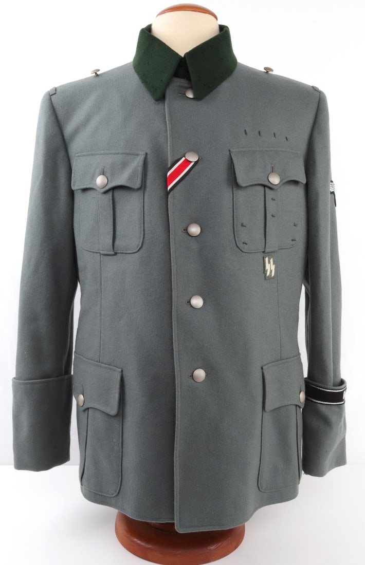 WWII GERMAN THIRD REICH SS COAT: German Third Reich SS uniform. Field gray with dark green collar. Silver-colored metallic buttons marked with "C. Erhoff and Co." and "19." Second button down has red, white, and black ribbon, which i