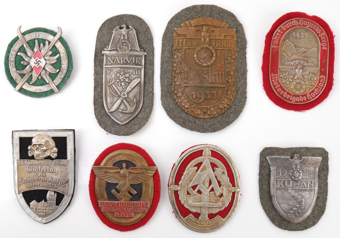 WWII GERMAN THIRD REICH SHIELD & BADGE LOT OF 8: Lot of 10 WWII German shields. Waffen SS 1934 Wintertag Skull badge, Kuban shield, German Army Narvik shield, NSFK 1939 Glider Flieger Korps badge, NSKK 1937 Motorbrigade "Hochland" badge, NSKK Bresla