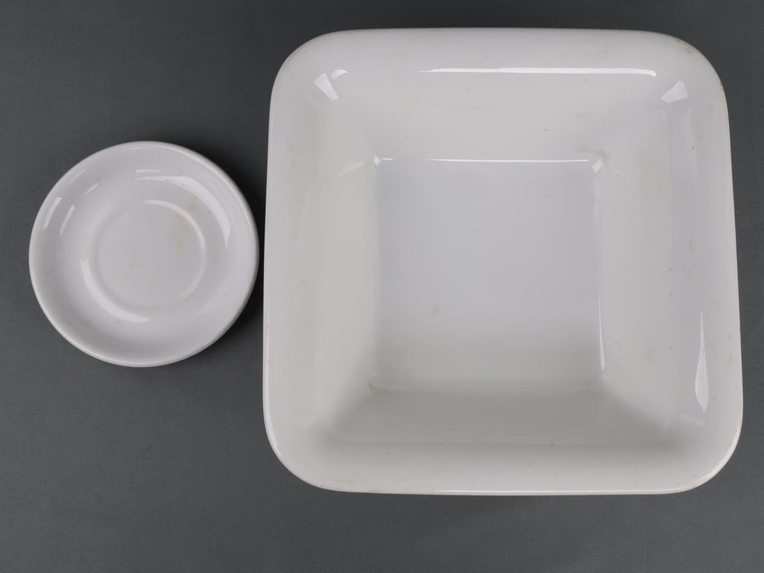 WWII GERMAN THIRD REICH SS MESS PORCELAIN LOT OF 2: Lot of 2 WWII German Third Reich mess items. Includes large porcelain bowl or basin. Square, 10X10 inches. Underside has "Hutschenreuther Selb Bavaria 1938 Bauscher Weiden SS Reich." Good condition. S