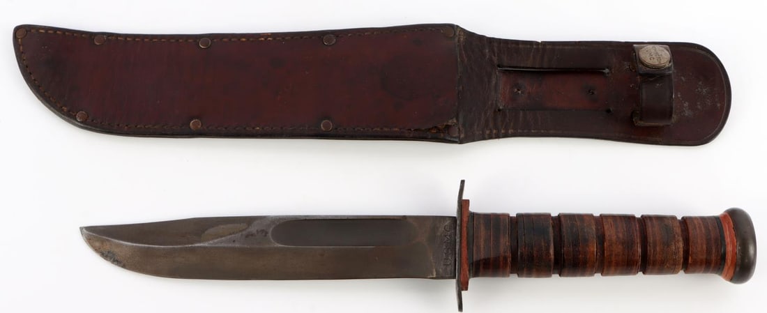 WWII FIGHTING KNIFE MK2 USMC PAL RED SPACER: WWII fighting knife. Ricasso stamped "PAL." Verso "USMC." Retains parkerized blade finish. Very slight play in the pommel disc. Blade length 7 inches. Includes leather scabbard stamped "Remington UMC"