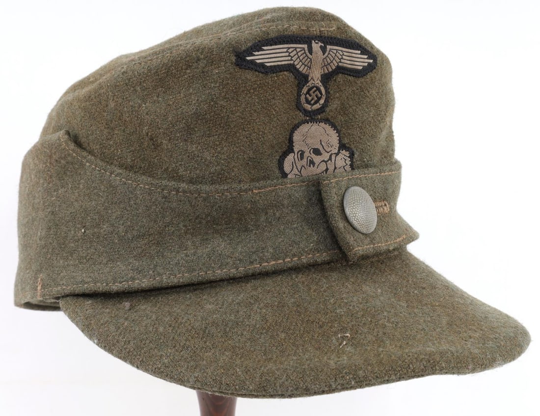 WWII GERMAN REICH WAFFEN SS EM/NCO M43 FIELD CAP: WWII German Reich green wool Waffen-SS Enlisted Men/ Non-commissioned Officer's M43 field cap. Cap features a party adler and totenkopf skull patch stitched onto the exterior along with a singular peb