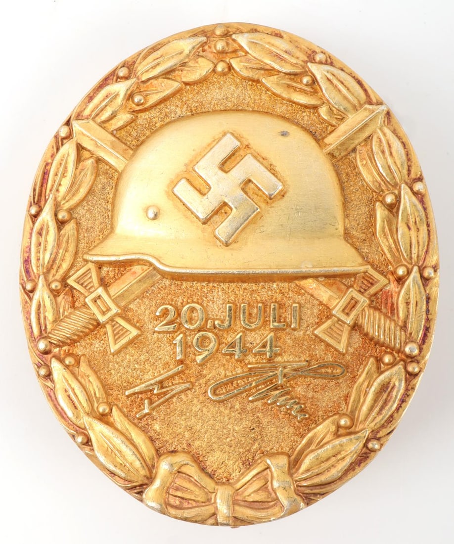 GERMAN THIRD REICH WOUND BADGE JULY 20 PLOT MEDAL: German Third Reich Juli 20, 1944 'Wound' Badge. Features a helmet with a swastika flanked by two swords and the text "Juli 20, 1944." Facsimile signature of H. Hitler. Back reads "L/12 800." Tested si