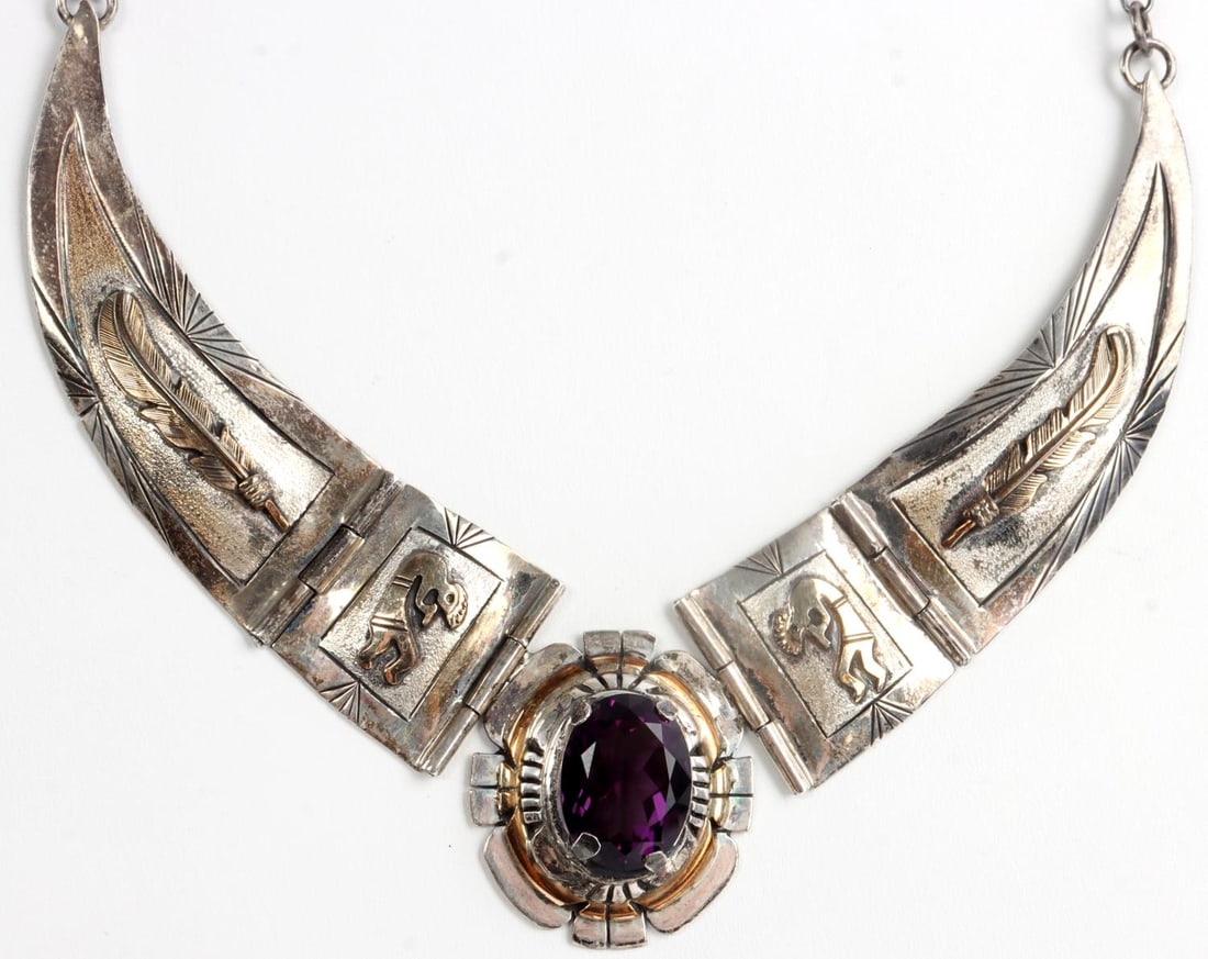 STERLING SILVER RUSSELL SAM NAVAJO NECKLACE: Sterling silver necklace in the Navajo style with 12k gold-filled decoration and a 6.5 carat amethyst. Decoration includes kokopeli flute player imagery as well as feathers. Stamped sterling and 12k g