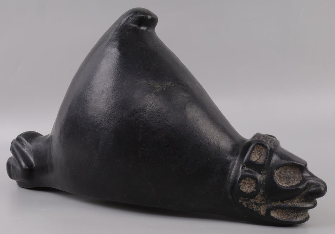 TAINO PRECOLOMBIAN BAT MAN ZEMI CARVING: Taino. PreColumbian. Large Bat man Zemi with upright, bat like ears. The subjects face is pleasingly formed with mouth slightly open and large headband connecting ears. The cone is bent sharply forwar
