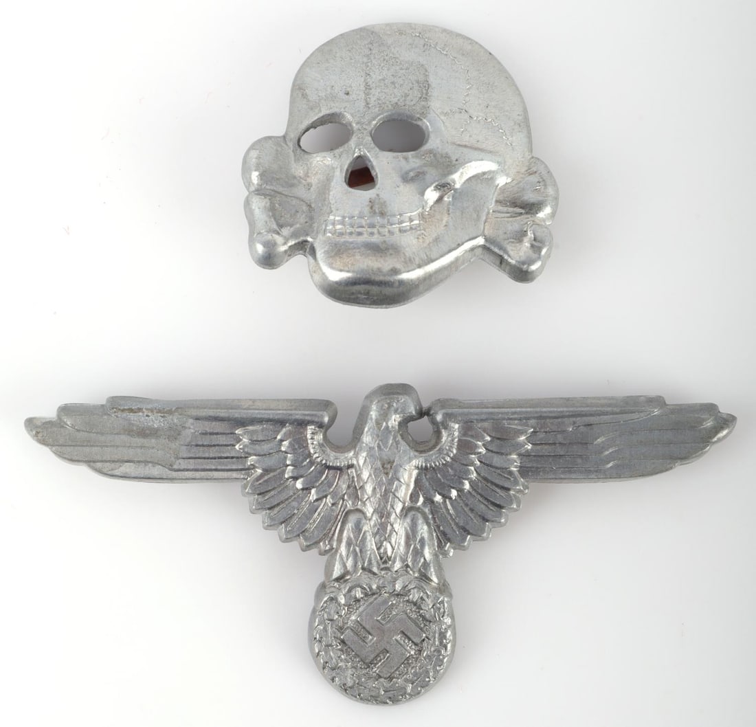 WWII GERMAN SS VISOR SET TOTENKOPF & PARTEIADLER: Zinc set marked RZM M1/24. Measure 1 and 2 3/4 inches. Very good condition. This lot has a reserve.