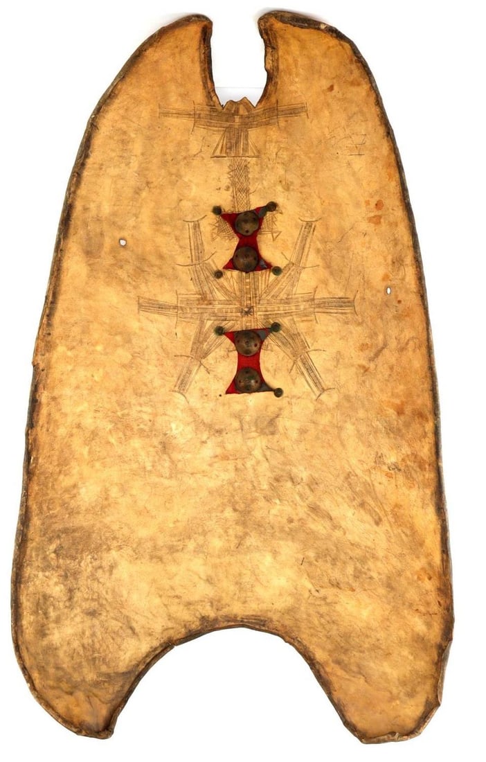 AFRICAN TUAREG ORYX AYAR SHIELD W BULLET DAMAGE: Tuareg ayar shield. Made from a single piece of Oryx hide with characteristic rolled edges daubed in black paint. The front top of the shield is marked with Berber sigils, and indicates that this shie